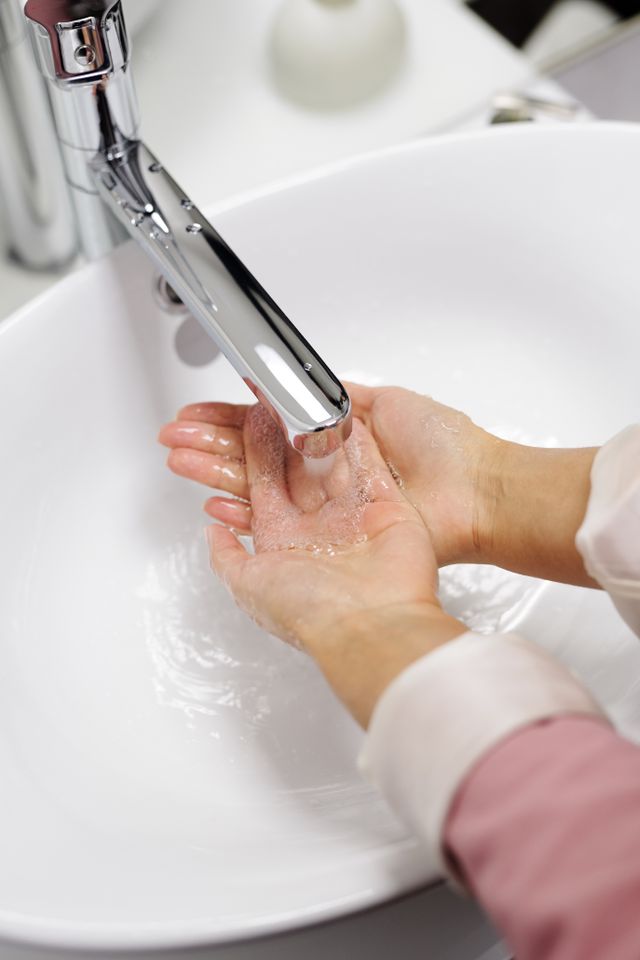 Person washing their hands with soap under running water.